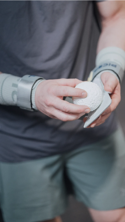 Persona aplicando magnesio en polvo con una bola sobre unas calleras de Crossfit
